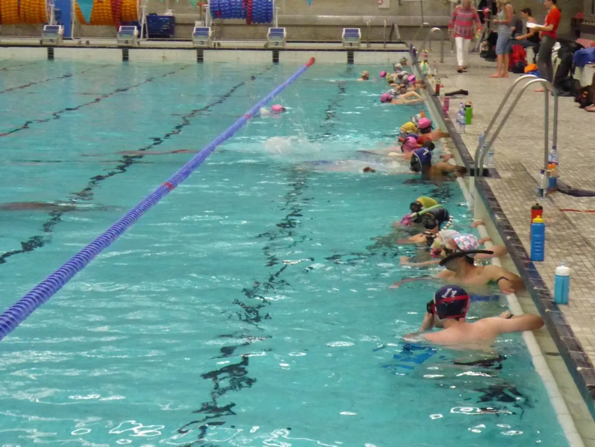 Counters and monitors tracking swimmer distances poolside
