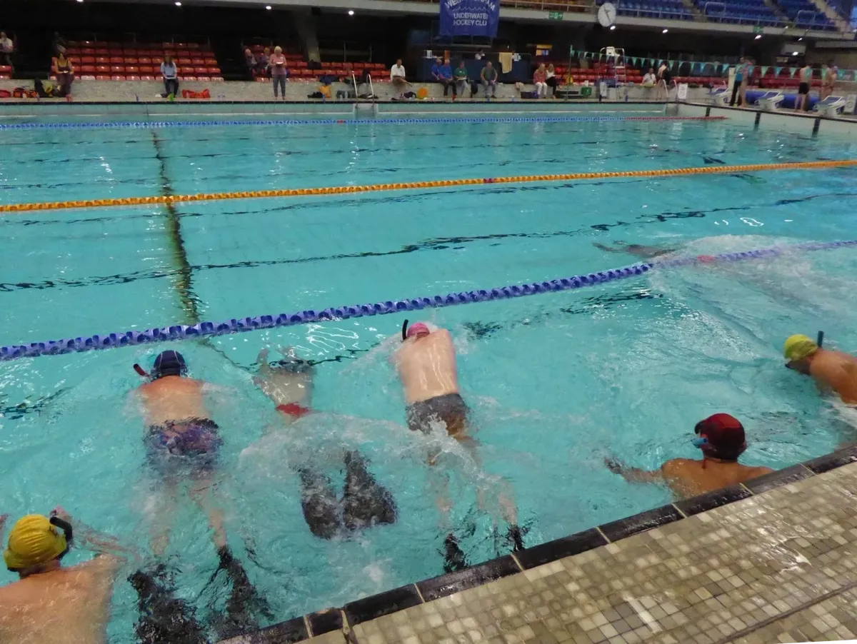 Club members cheering on swimmers from the pool edge